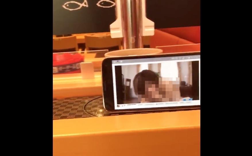レーンを流れるスマホにうつるアダルト動画（加工は編集部）