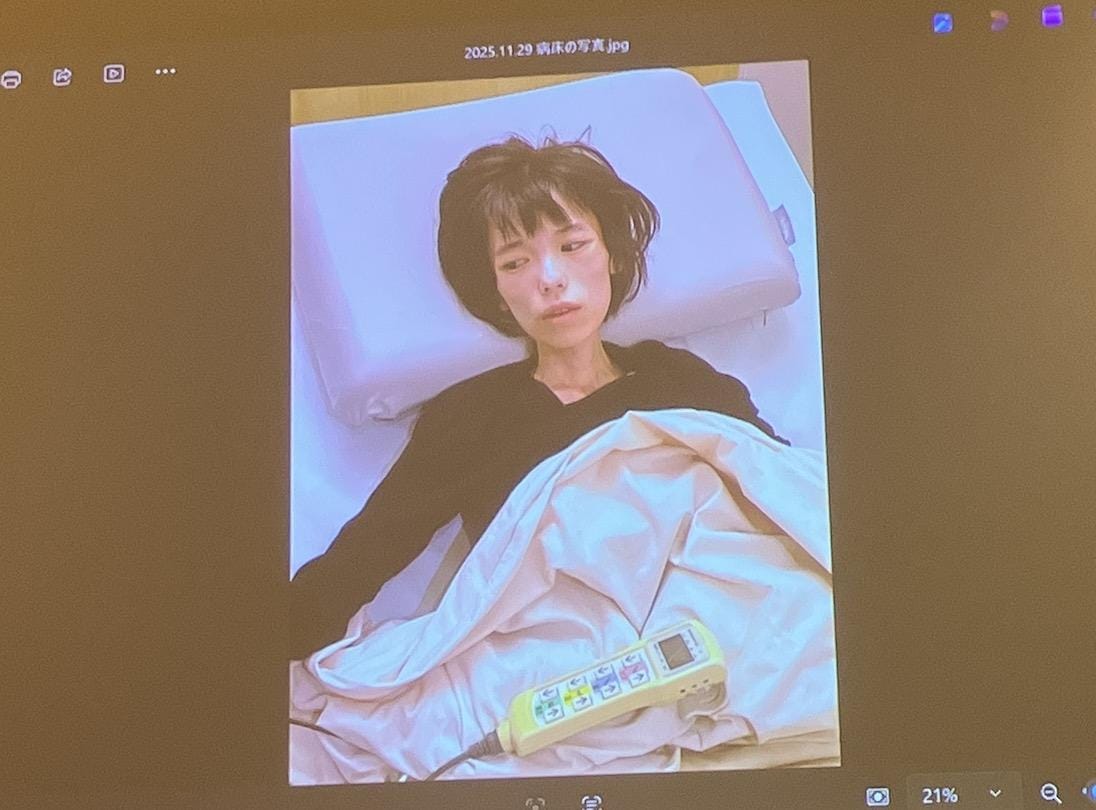 亡くなる直前に撮影された女性（会見場のスクリーンに映し出された写真を弁護士ドットコムニュースが撮影）